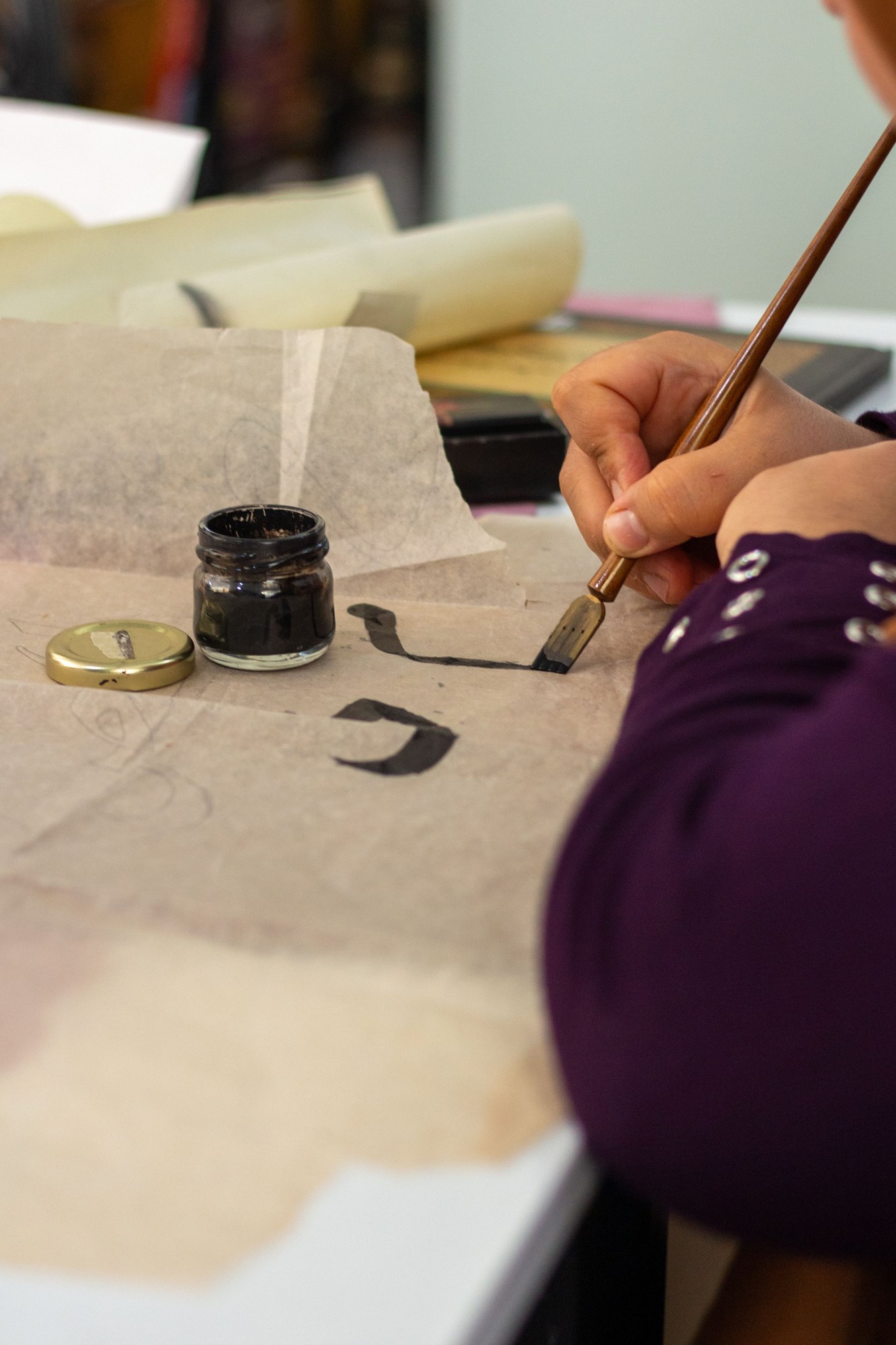 Brush pushing black ink across textured Korean-style paper